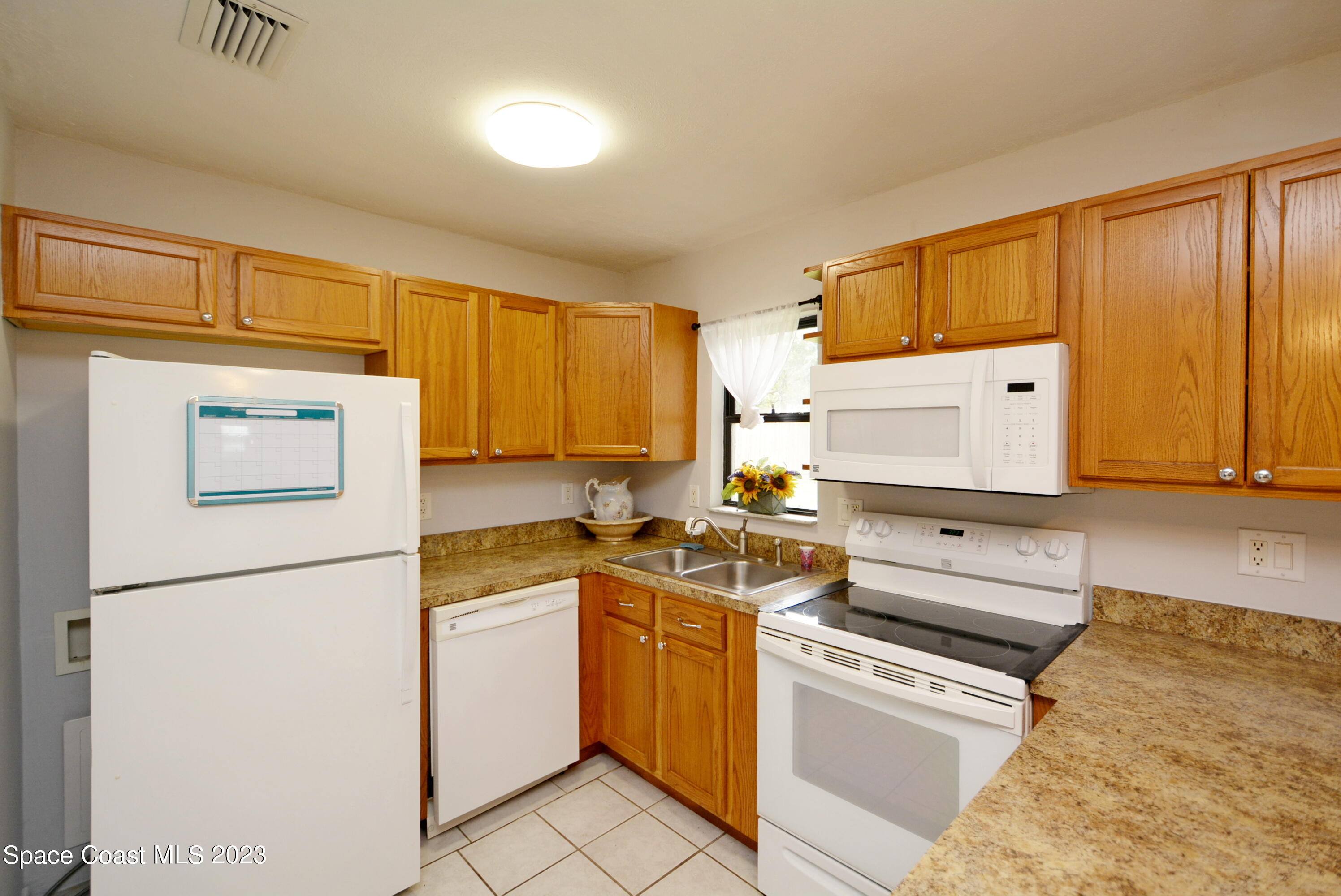 2579 Coventry Road Melbourne, FL 32935 - Photo 16 of 36 a kitchen with a stove top oven sink and a refrigerator