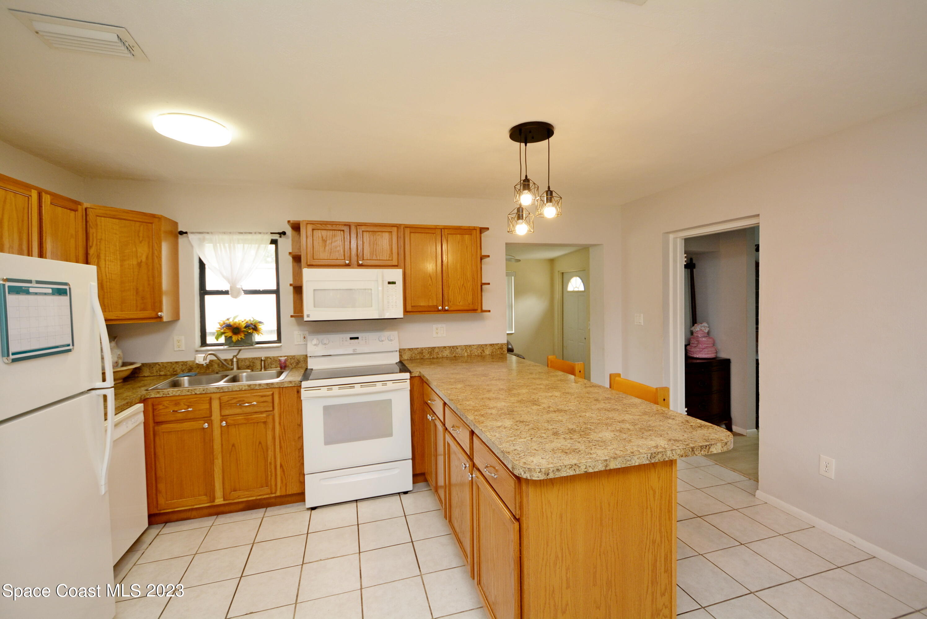 2579 Coventry Road Melbourne, FL 32935 - Photo 17 of 36 a kitchen with a stove a refrigerator and a sink