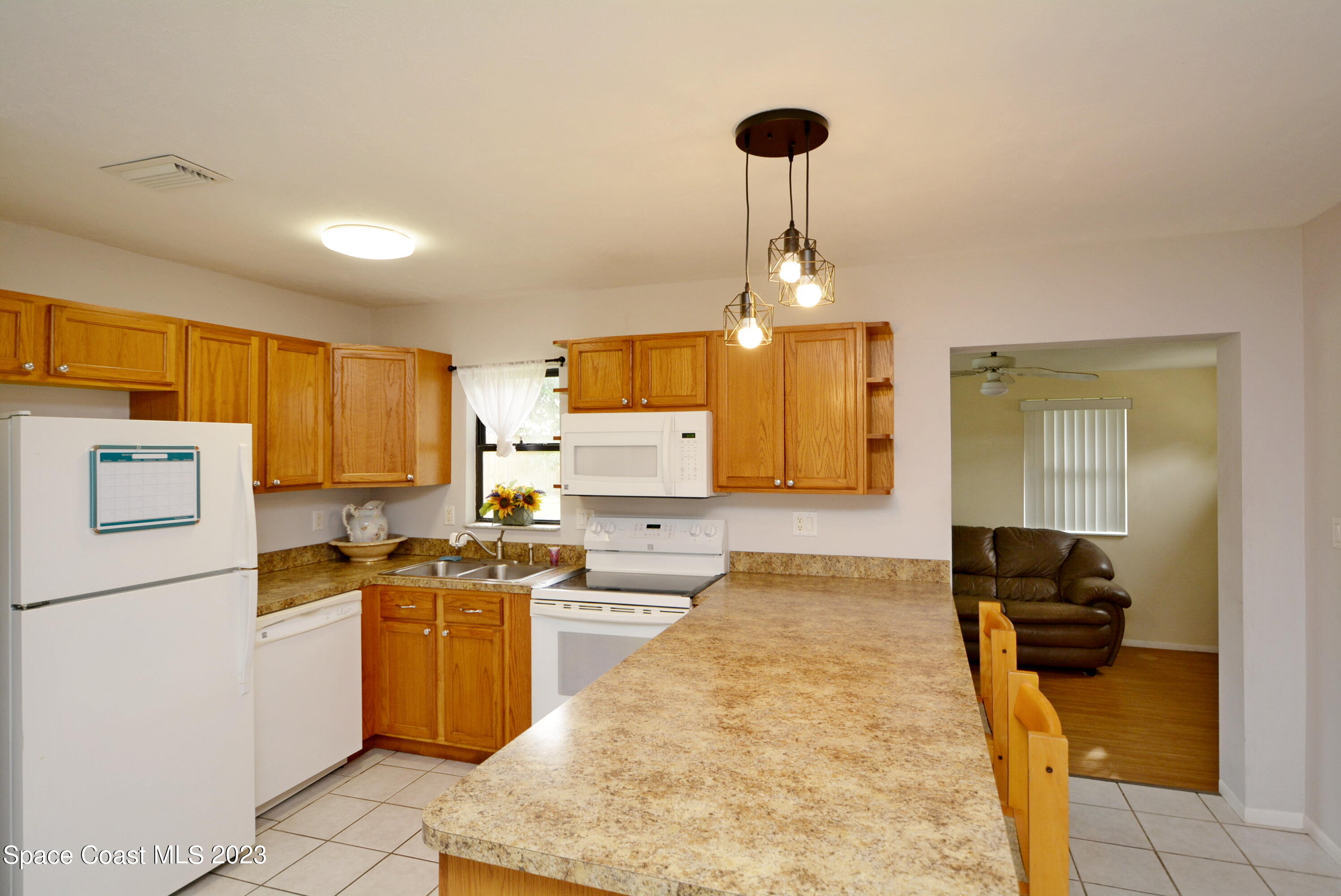 2579 Coventry Road Melbourne, FL 32935 - Photo 18 of 36 a kitchen with stainless steel appliances granite countertop a sink a stove and a refrigerator