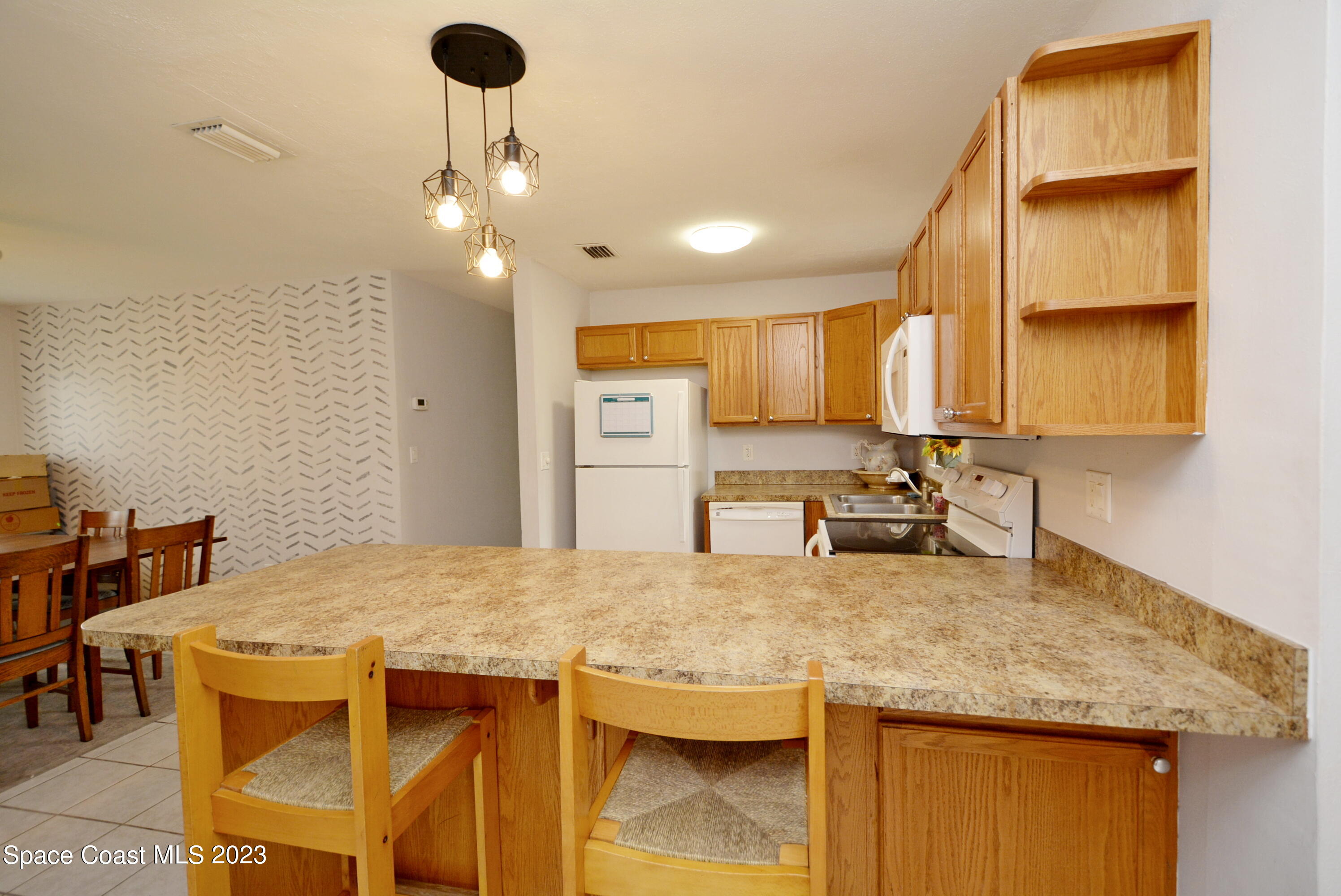 2579 Coventry Road Melbourne, FL 32935 - Photo 19 of 36 a kitchen with stainless steel appliances granite countertop a sink a stove and a refrigerator