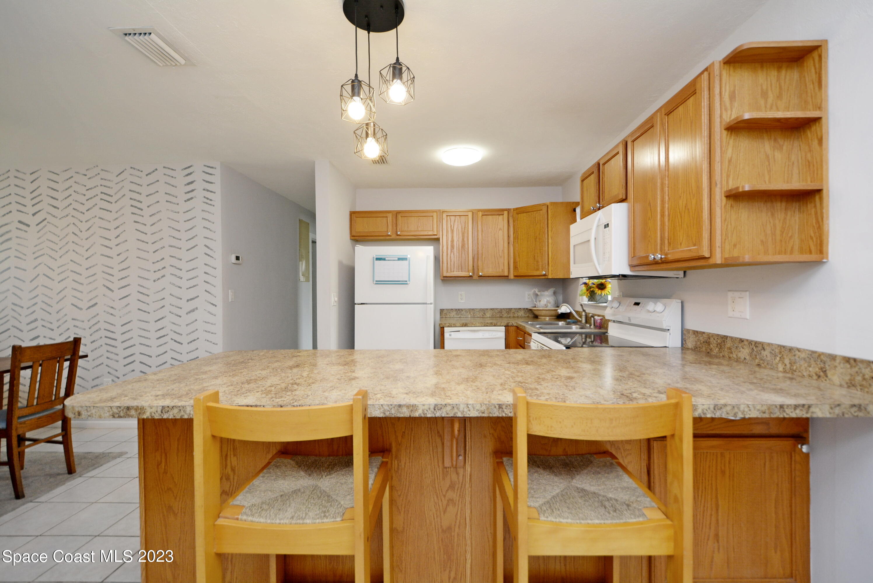 2579 Coventry Road Melbourne, FL 32935 - Photo 20 of 36 a kitchen with stainless steel appliances granite countertop a sink refrigerator and cabinets