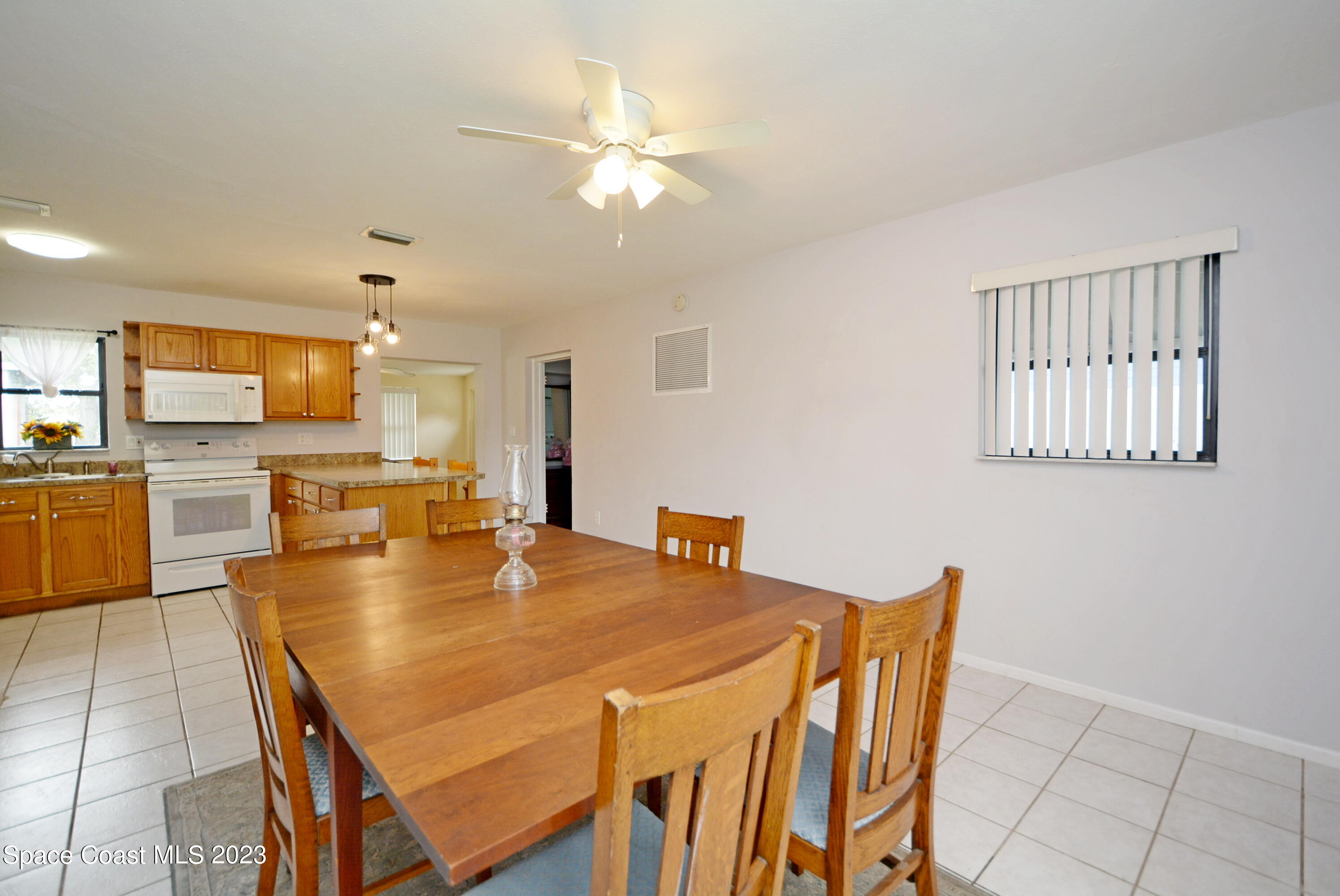 2579 Coventry Road Melbourne, FL 32935 - Photo 24 of 36 a view of a dining room and livingroom with furniture wooden floor a chandelier