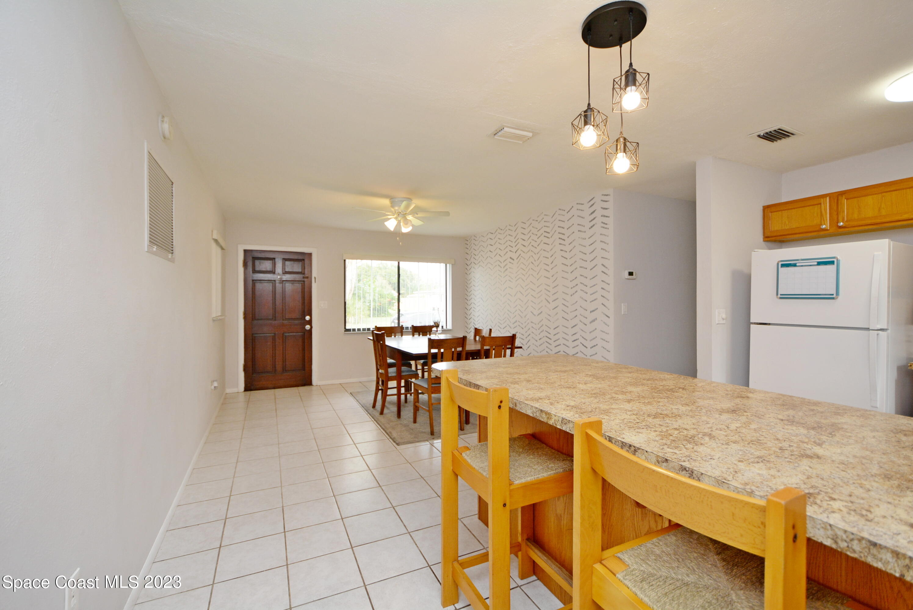 2579 Coventry Road Melbourne, FL 32935 - Photo 25 of 36 a view of a dining room with furniture and a chandelier