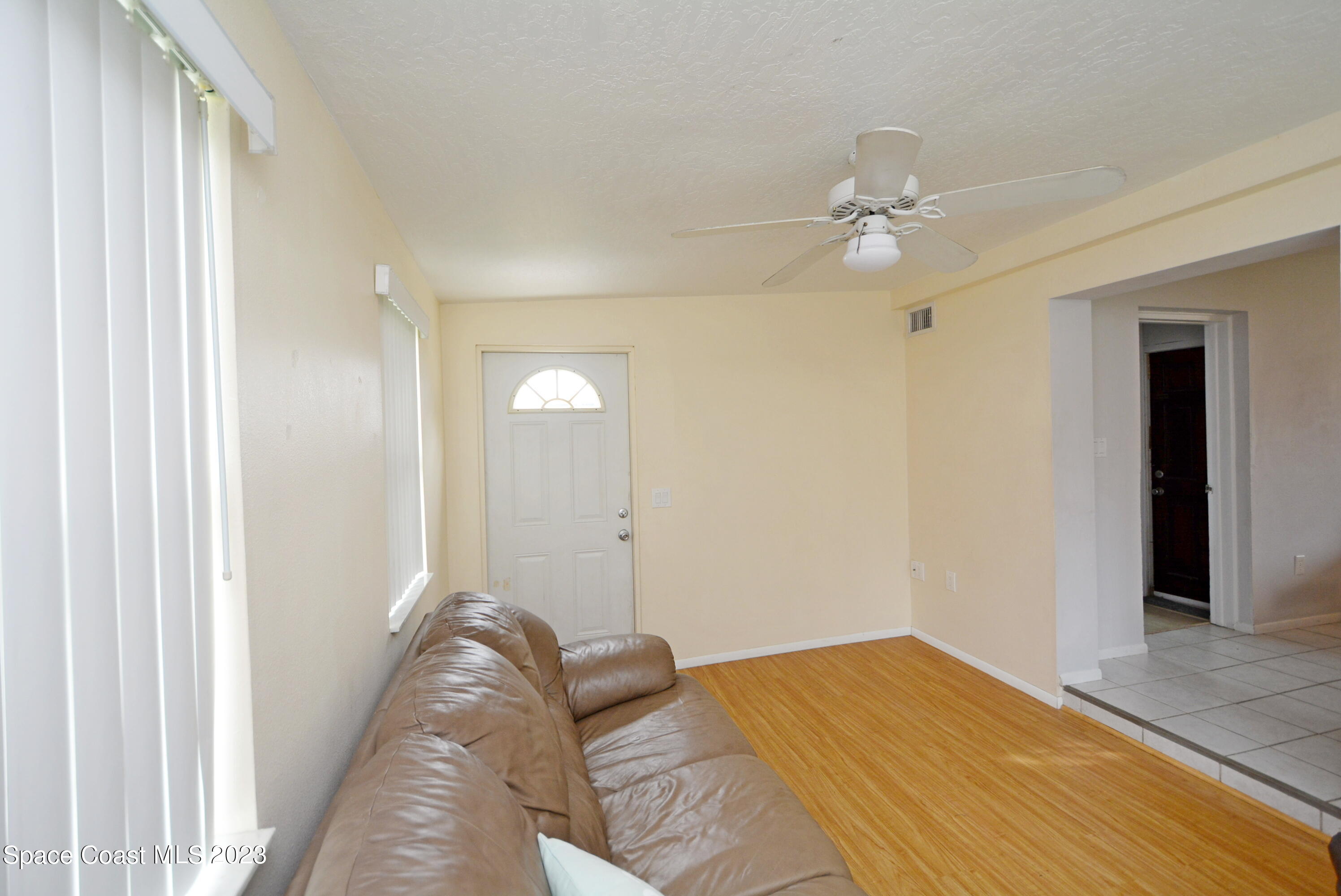 2579 Coventry Road Melbourne, FL 32935 - Photo 7 of 36 a bedroom with a bed and a chandelier