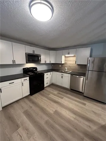 a large kitchen with cabinets stainless steel appliances and a counter space