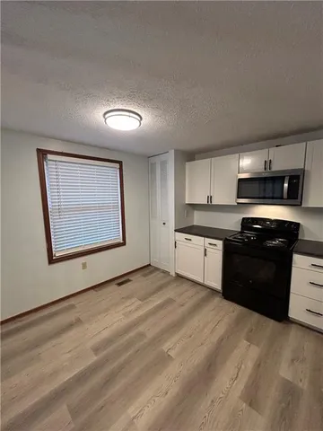 a large kitchen with a stove top oven and sink
