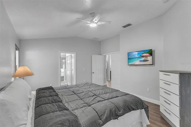 a bedroom with a large bed and a chandelier