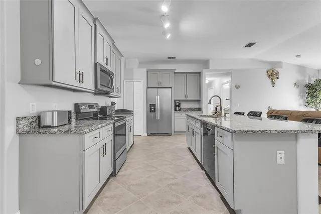 a kitchen with stainless steel appliances granite countertop a sink and stove