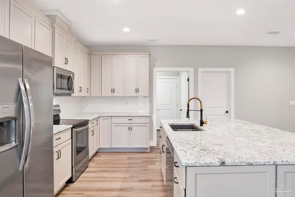 a kitchen with stainless steel appliances granite countertop a sink stove and refrigerator