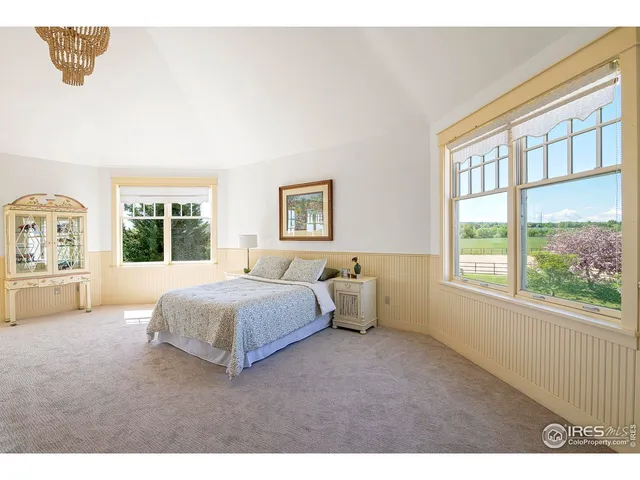a spacious bedroom with a bed and a large window