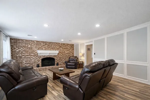 a kitchen with stainless steel appliances a stove a sink and white cabinets with wooden floor