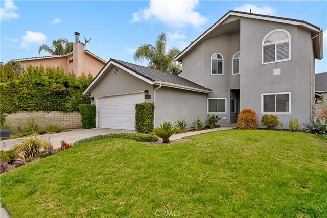 a front view of house with yard and garage