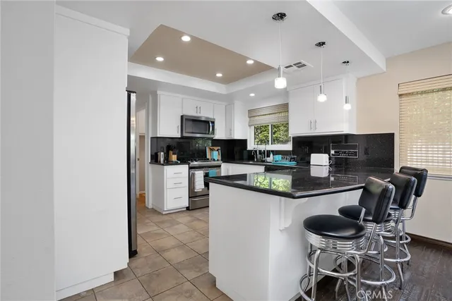 a kitchen with stainless steel appliances granite countertop a stove top oven a sink dishwasher and a refrigerator