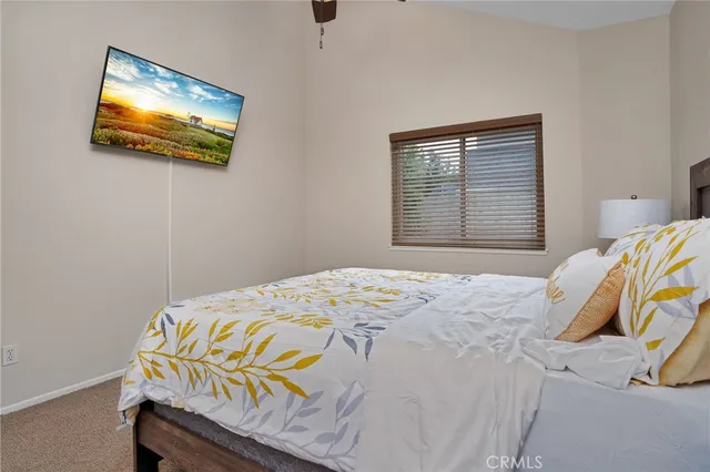 a bedroom with a bed and a painting on the wall