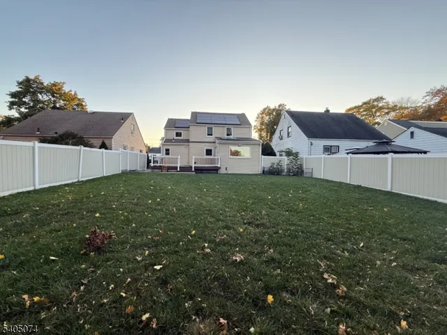 a view of a house with a big yard and large trees