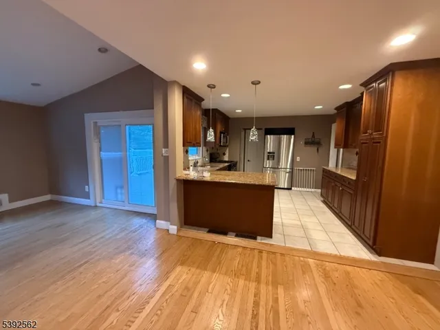 a view of kitchen with refrigerator and wooden floor