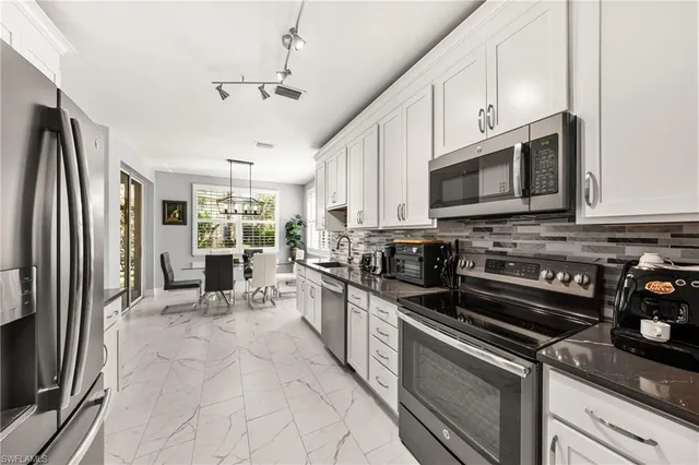 a kitchen with stainless steel appliances granite countertop a stove refrigerator and microwave