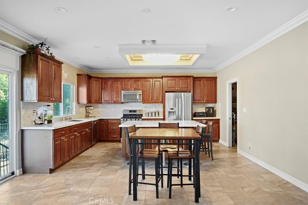 14012 Quailridge Drive Riverside, CA 92503 - Photo 12 of 44 a kitchen with stainless steel appliances a table and chairs in it