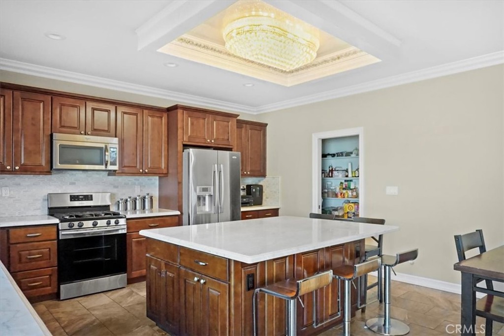 14012 Quailridge Drive Riverside, CA 92503 - Photo 15 of 44 a kitchen with stainless steel appliances granite countertop a stove a refrigerator a sink a dining table and chairs with wooden floor