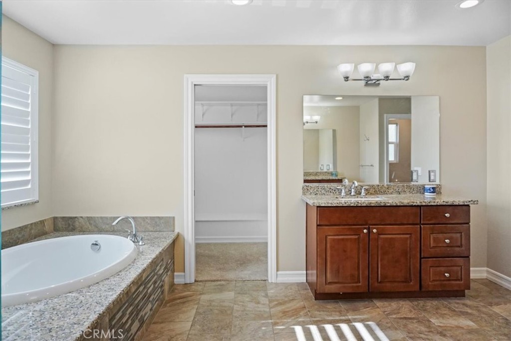 14012 Quailridge Drive Riverside, CA 92503 - Photo 29 of 44 a spacious bathroom with a granite countertop tub sink and mirror