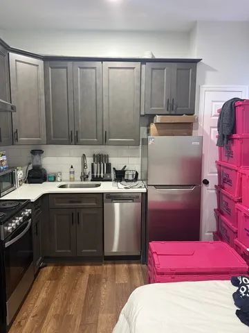 a kitchen with a refrigerator sink and cabinets