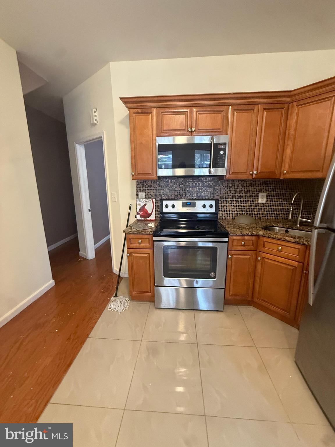 4917 North 12th Street Philadelphia, PA 19141 - Photo 2 of 5 a kitchen with stainless steel appliances granite countertop a stove a sink and a microwave