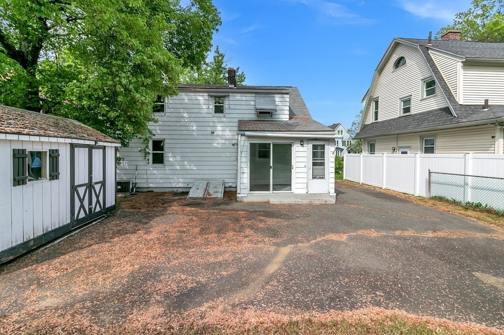 122 Prentice Street Springfield, MA 01104 - Photo 29 of 32 a view of a white house with large windows and a small yard