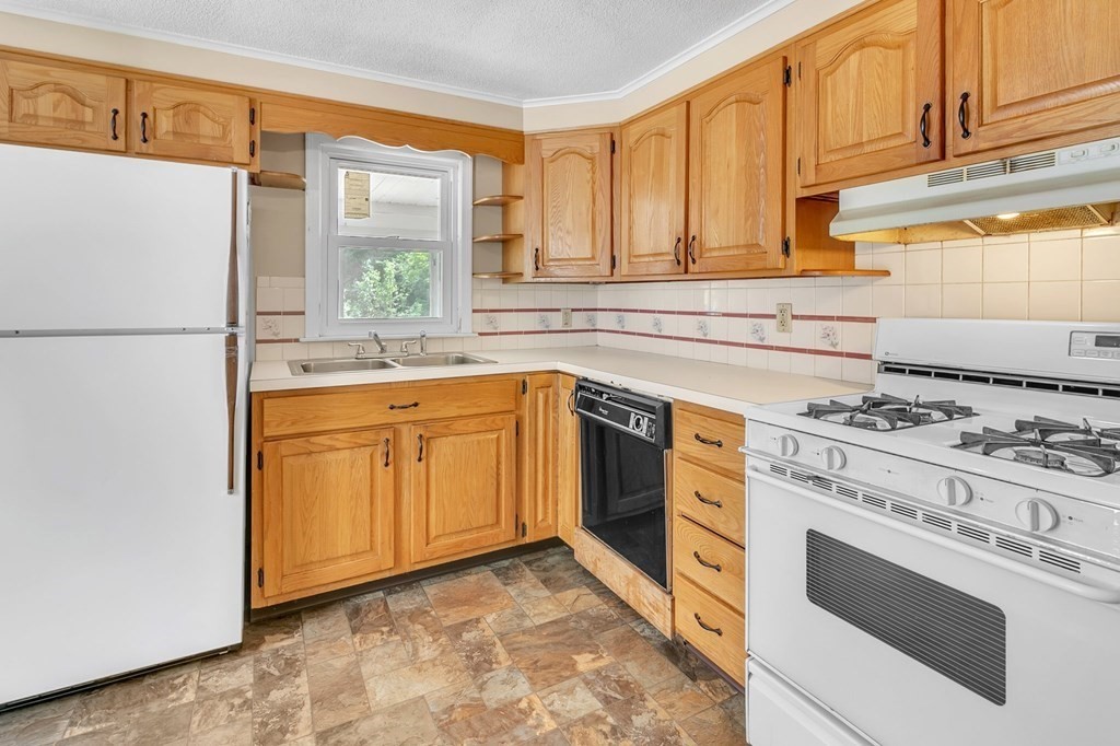 122 Prentice Street Springfield, MA 01104 - Photo 6 of 32 a kitchen with a stove a sink and a refrigerator