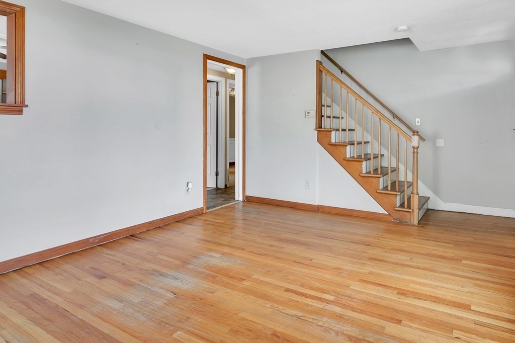 122 Prentice Street Springfield, MA 01104 - Photo 8 of 32 a view of an empty room with wooden floor and stairs