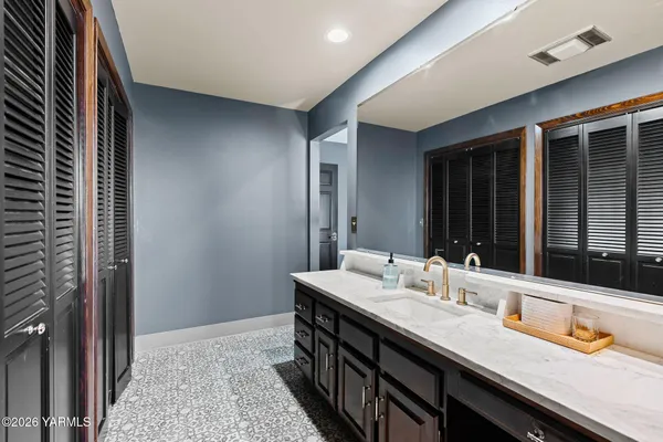 a en suite bathroom with a granite countertop sink and a mirror