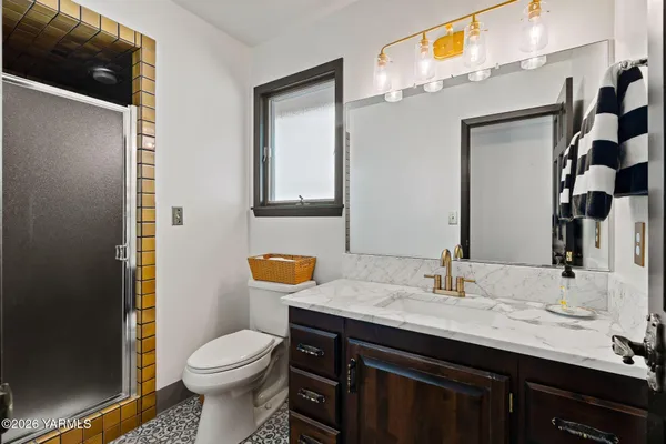 a bathroom with a sink a toilet a shower and a mirror