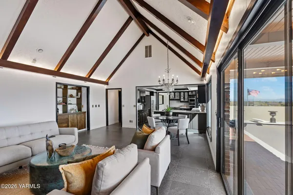 a dining room with furniture and a floor to ceiling window