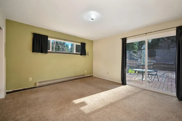 a view of a livingroom with furniture and floor to ceiling window