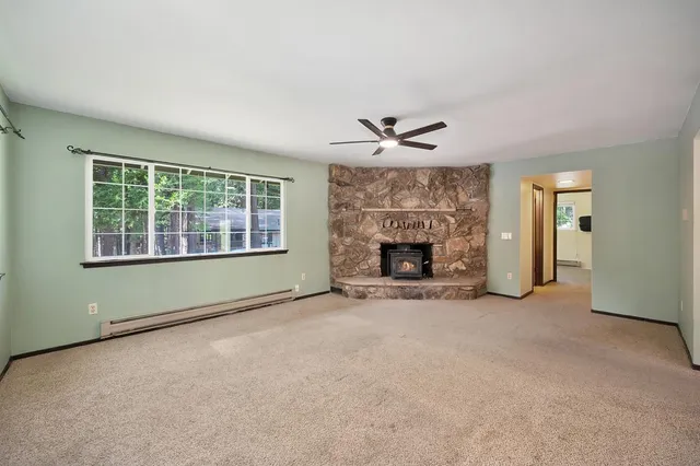 an empty room with windows and fireplace