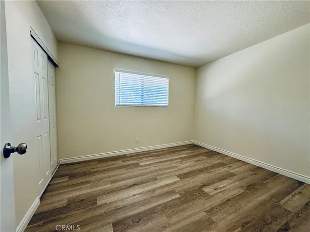 an empty room with wooden floor ceiling fan and windows