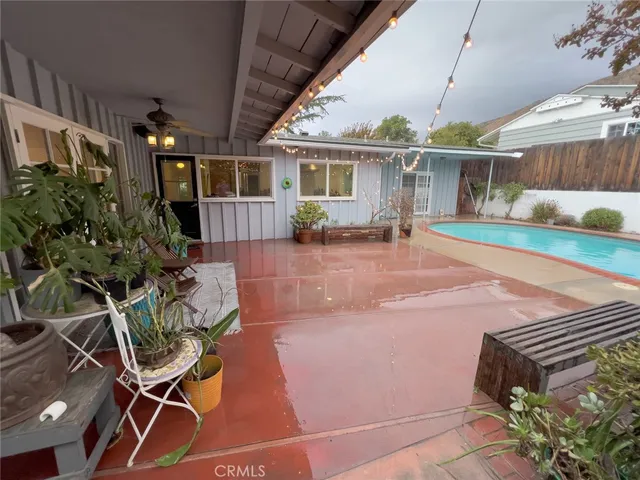 a backyard of a house with table and chairs potted plants