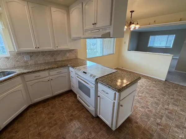 a kitchen with stainless steel appliances granite countertop a stove top oven a sink a counter space and cabinets