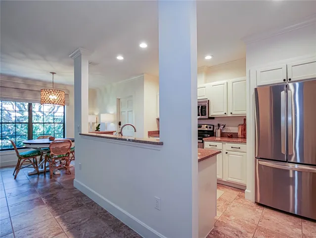 a kitchen with stainless steel appliances granite countertop a refrigerator and a table