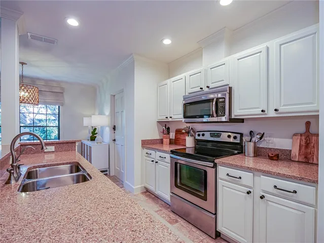 a kitchen with stainless steel appliances a stove a microwave a sink and cabinets
