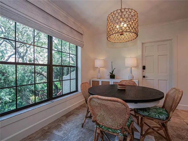 a dining room with furniture a rug and a large window