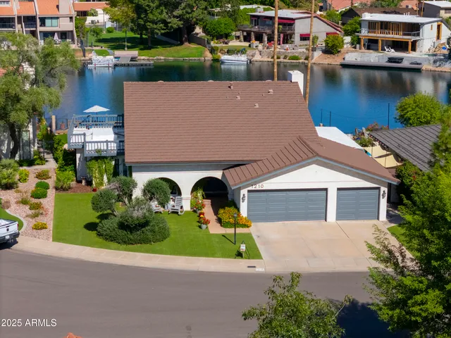 an aerial view of a house with a garden and lake view
