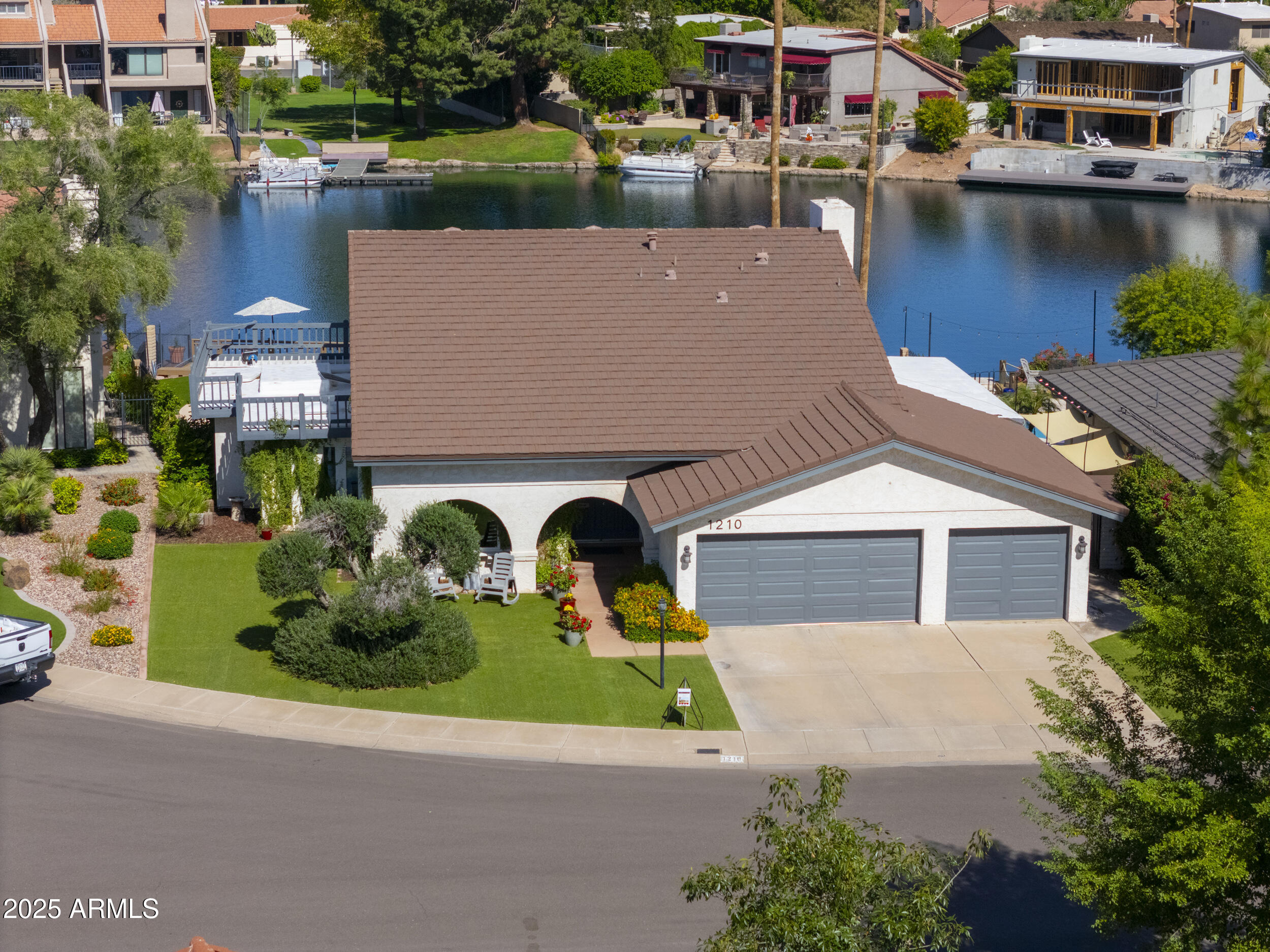 an aerial view of a house with a garden and lake view