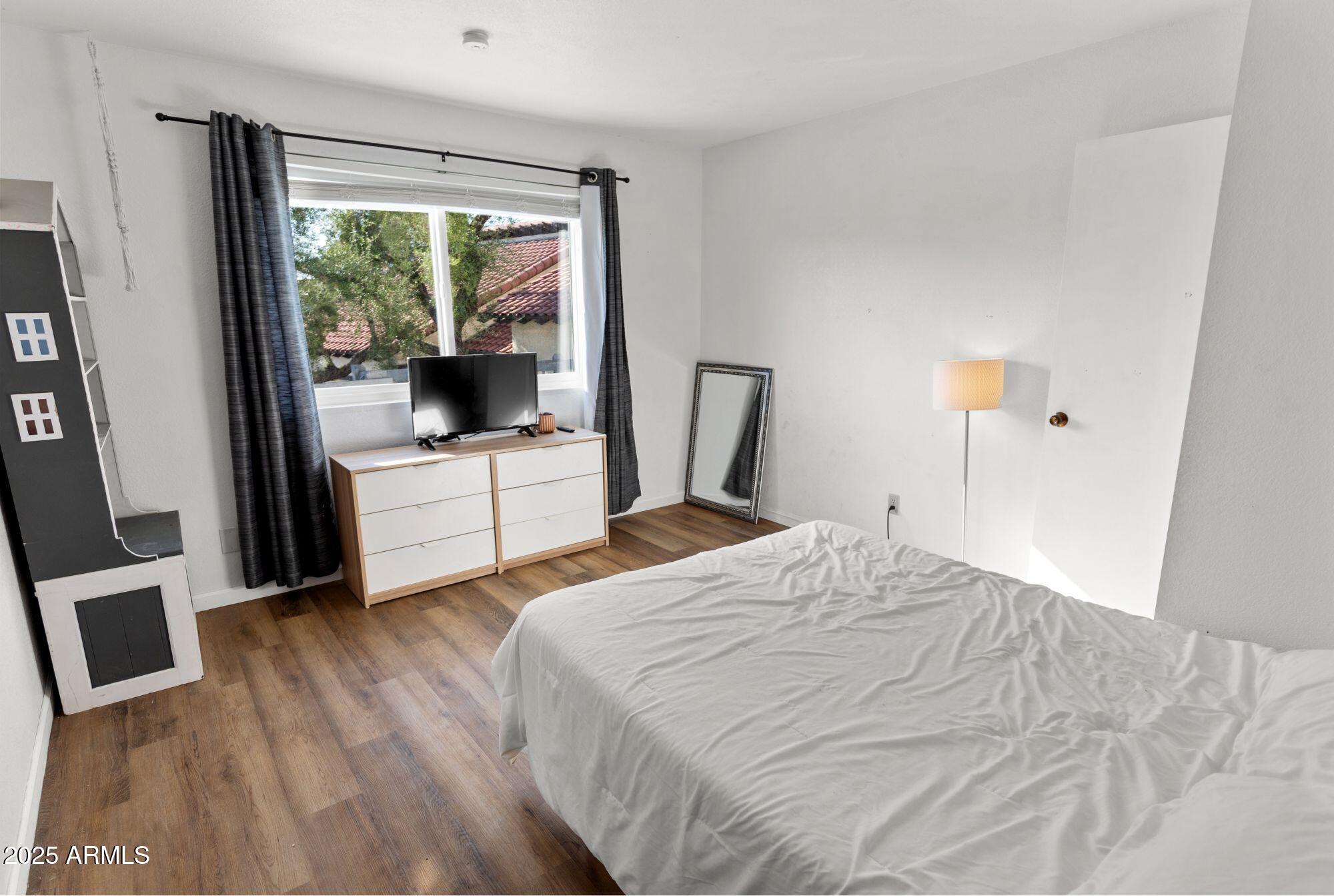 1210 East Harbor View Drive Tempe, AZ 85283 - Photo 43 of 68 a bedroom with a bed and a flat tv screen on the dresser