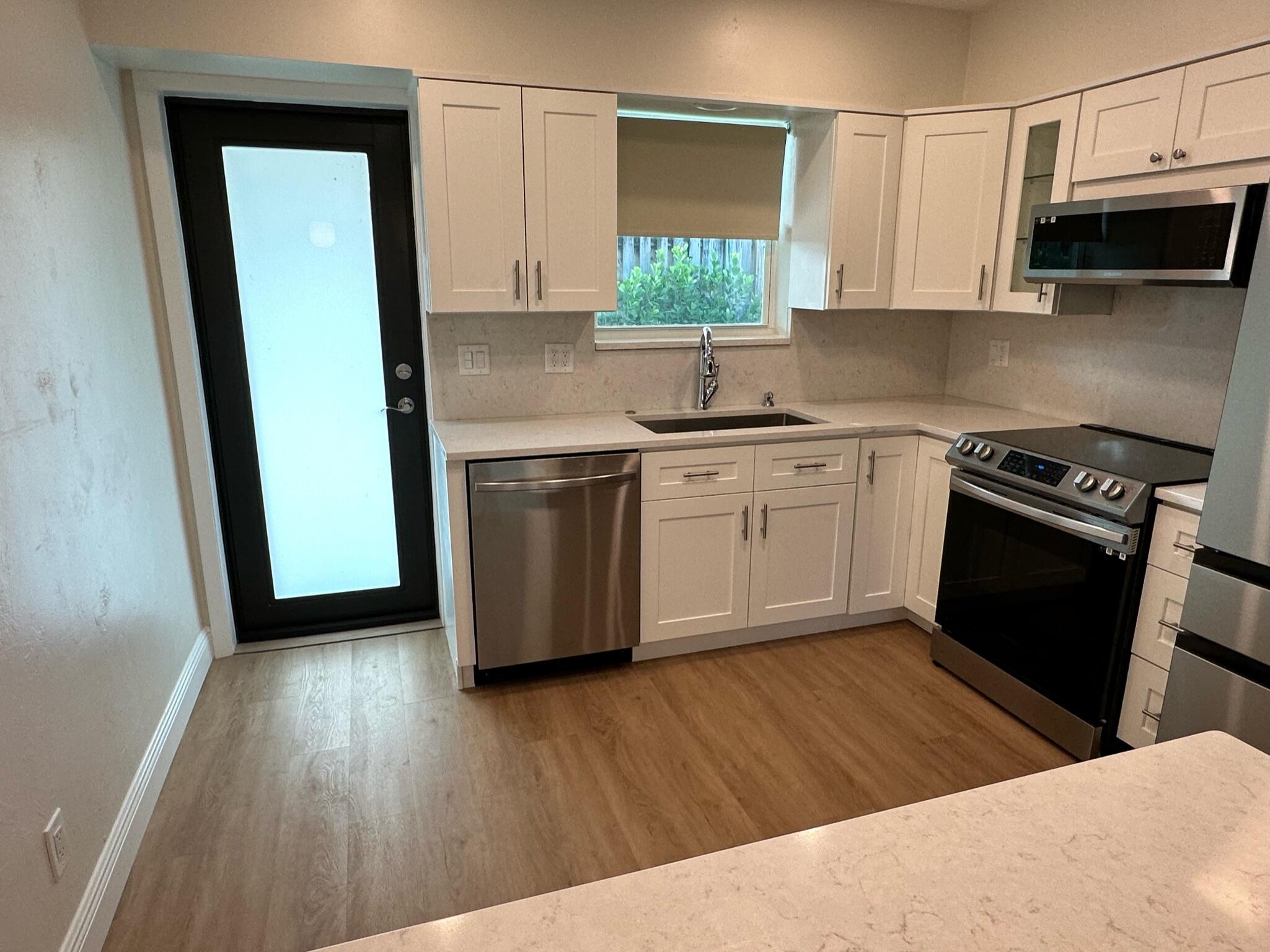 2018 Spanish Trail, Unit 2 Delray Beach, FL 33483 - Photo 7 of 13 a kitchen with stainless steel appliances granite countertop a sink stove and refrigerator