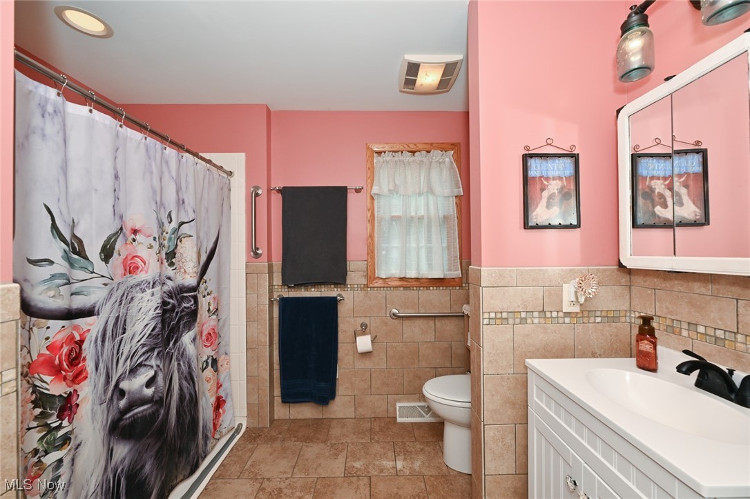 2150 Wise Road Green, OH 44720 - Photo 26 of 50 Bathroom featuring tile walls, tile patterned floors, toilet, and vanity