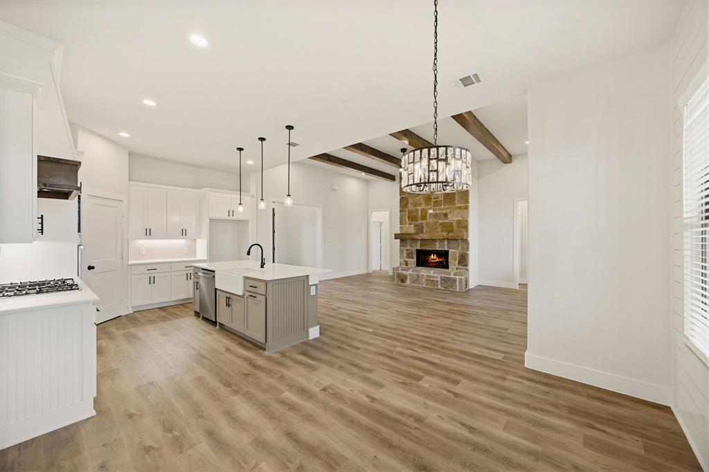 6713 Odom Road Sanger, TX 76266 - Photo 11 of 32 a open kitchen with white cabinets and wooden floor