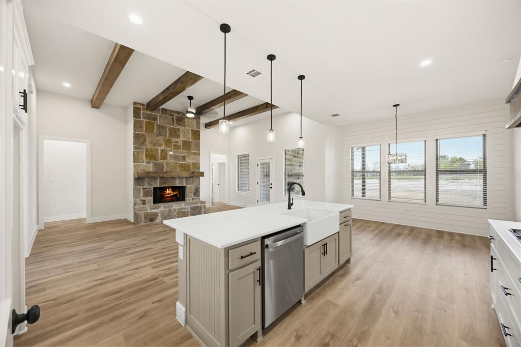 6713 Odom Road Sanger, TX 76266 - Photo 12 of 32 a large kitchen with kitchen island a stove a sink a center island and wooden floor
