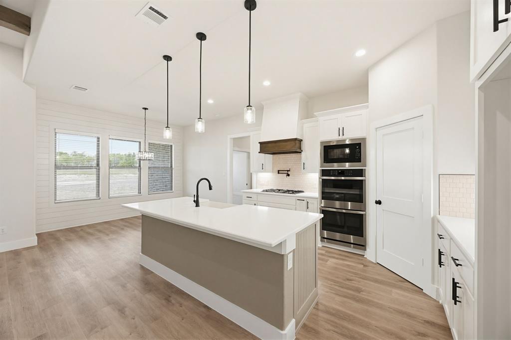 6713 Odom Road Sanger, TX 76266 - Photo 13 of 32 a large white kitchen with sink and refrigerator