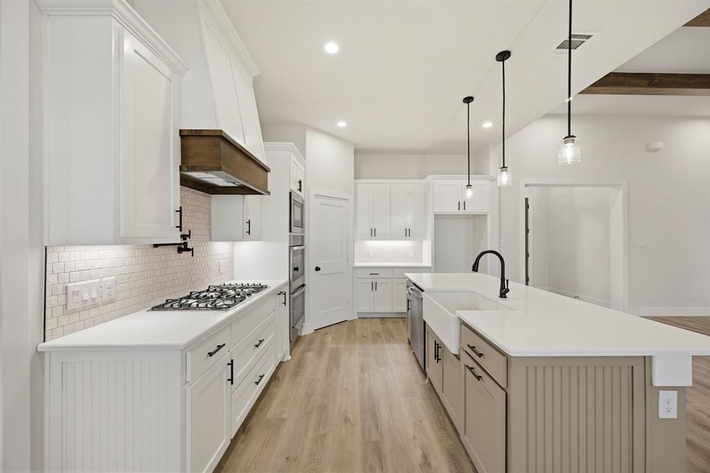 6713 Odom Road Sanger, TX 76266 - Photo 14 of 32 a kitchen with stainless steel appliances a stove a sink a refrigerator and a wooden floor