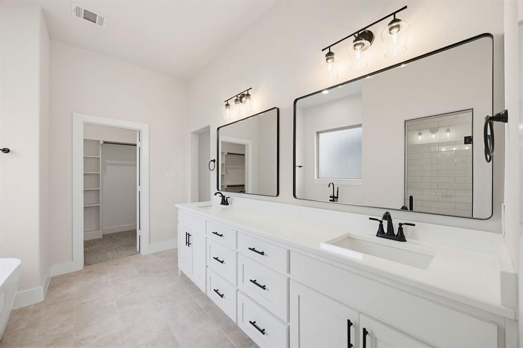 6713 Odom Road Sanger, TX 76266 - Photo 25 of 32 a bathroom with double vanity sink and mirror